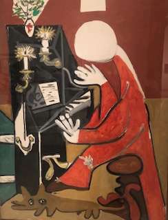 Abstract painting of a woman playing the piano with candles and a dog in the foreground at the Picasso Museum